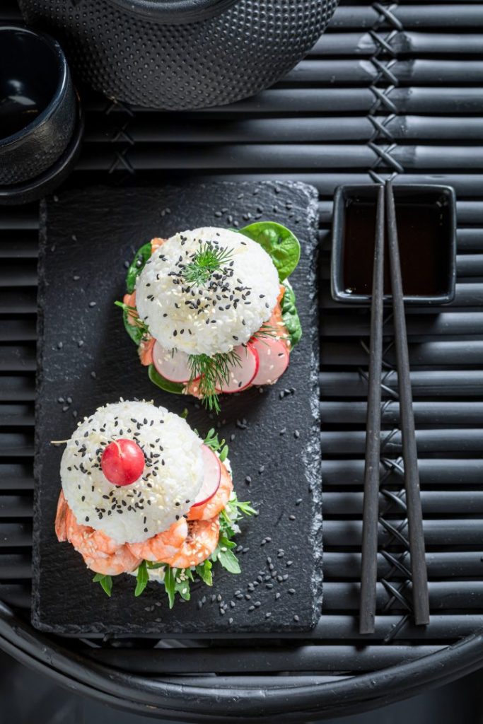 Tasty sush burger with salmon and avocado sprinkled with sesame.